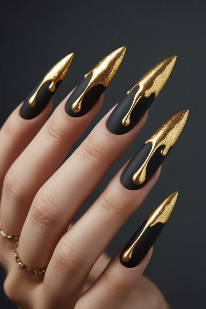 24. Black Stiletto Nails with Dripping Gold Art