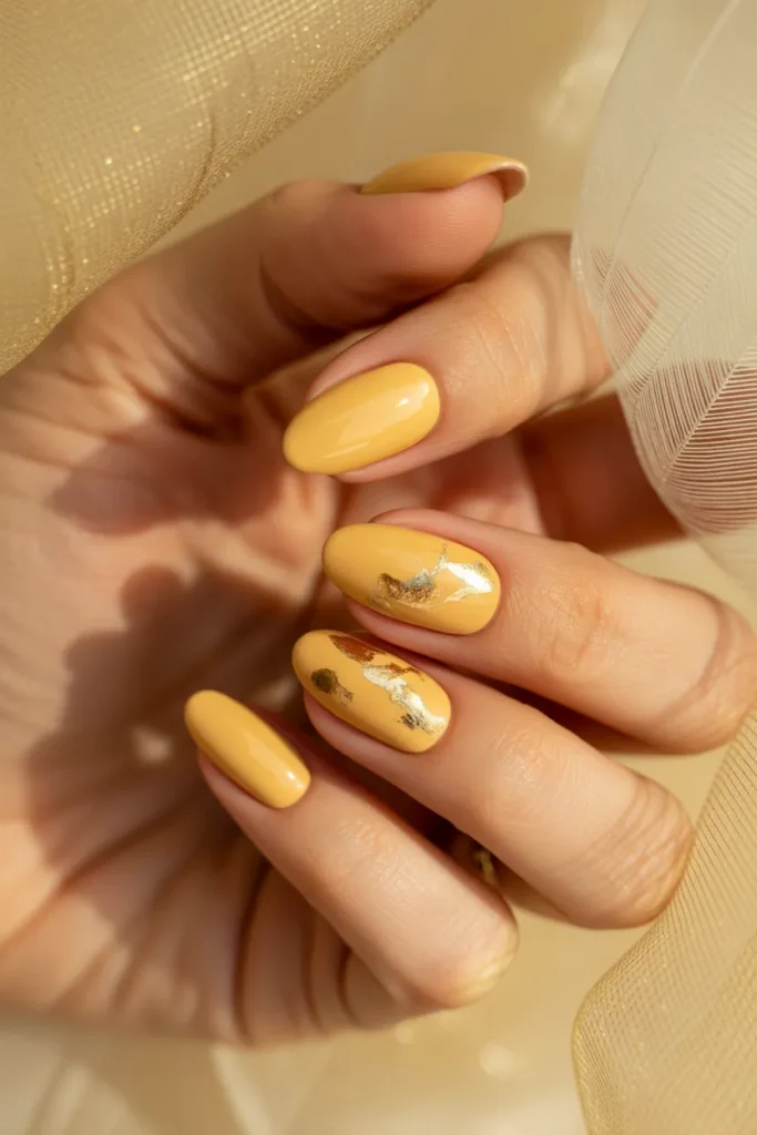 3. Butter Yellow Almond Nails with Gold Foil