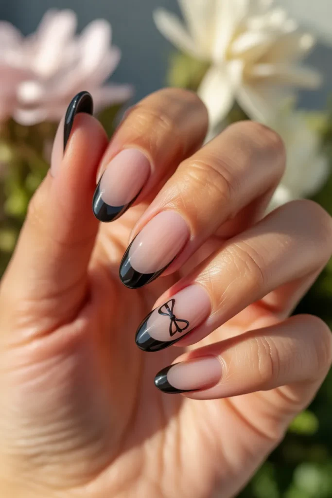 10. Black French Tip Almond Nails with Bow Accent